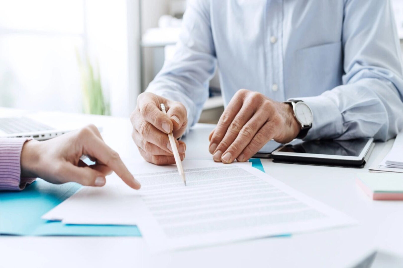 Two hands pointing at a document.