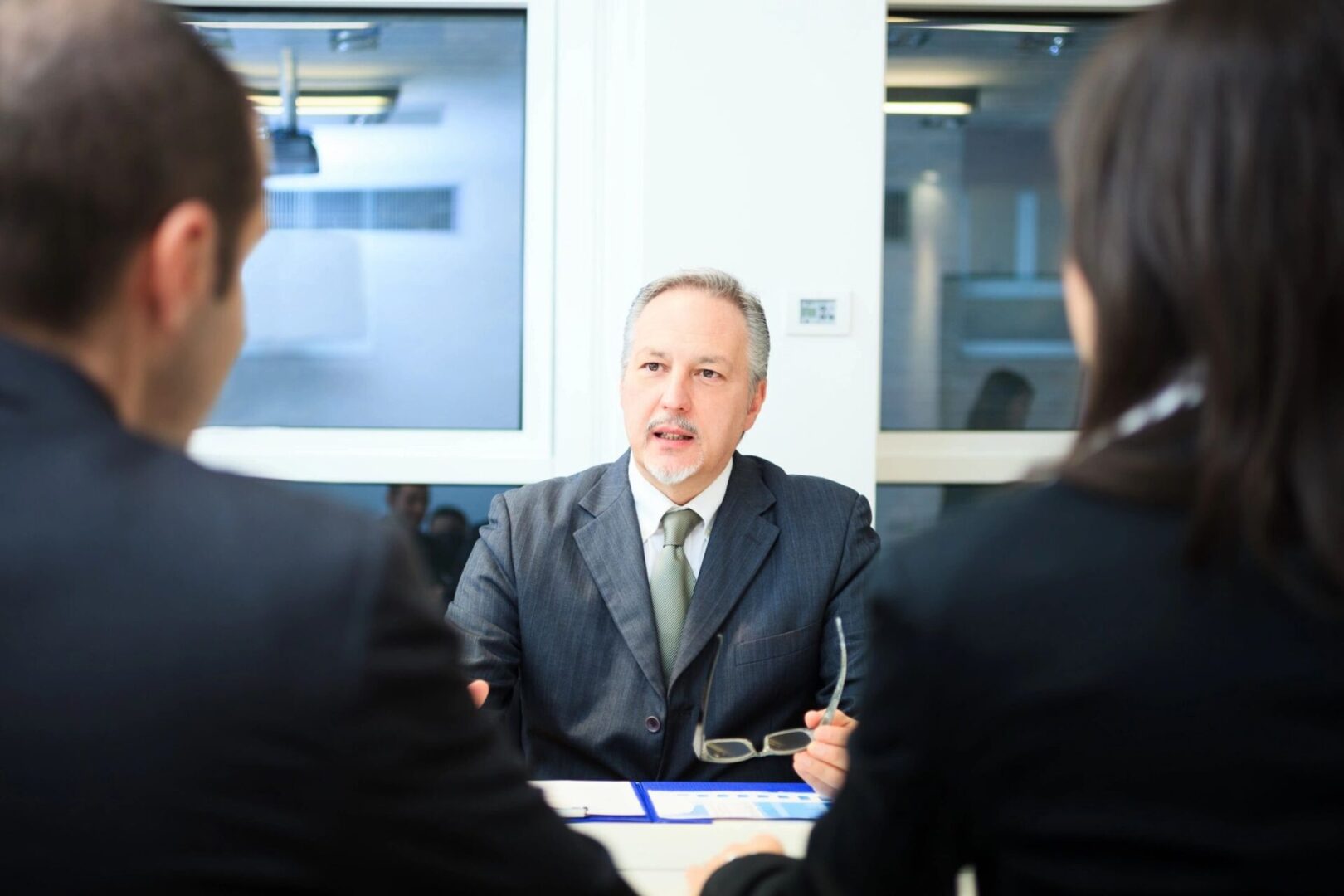 Businessman talking to colleagues during meeting.