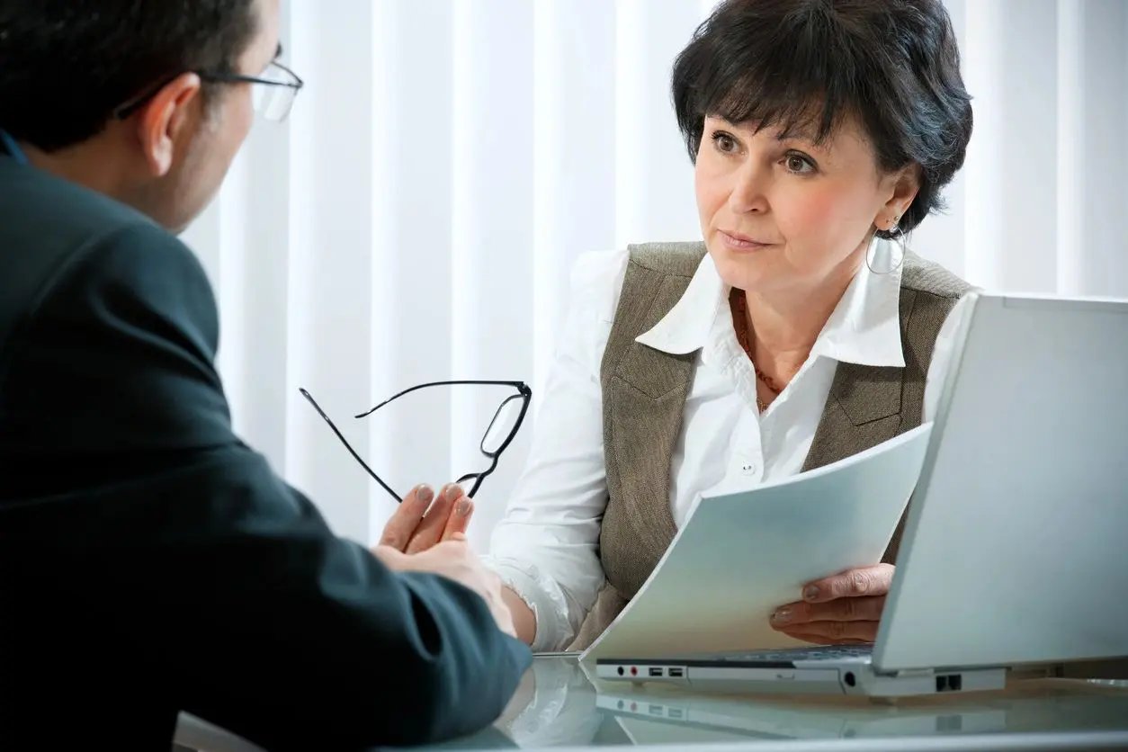 Businesswoman discussing document with client.