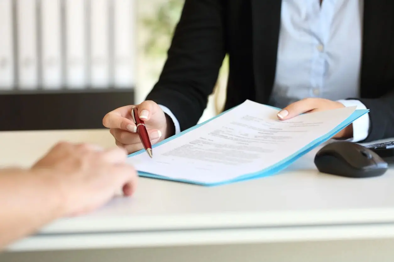 Woman signing contract with pen.