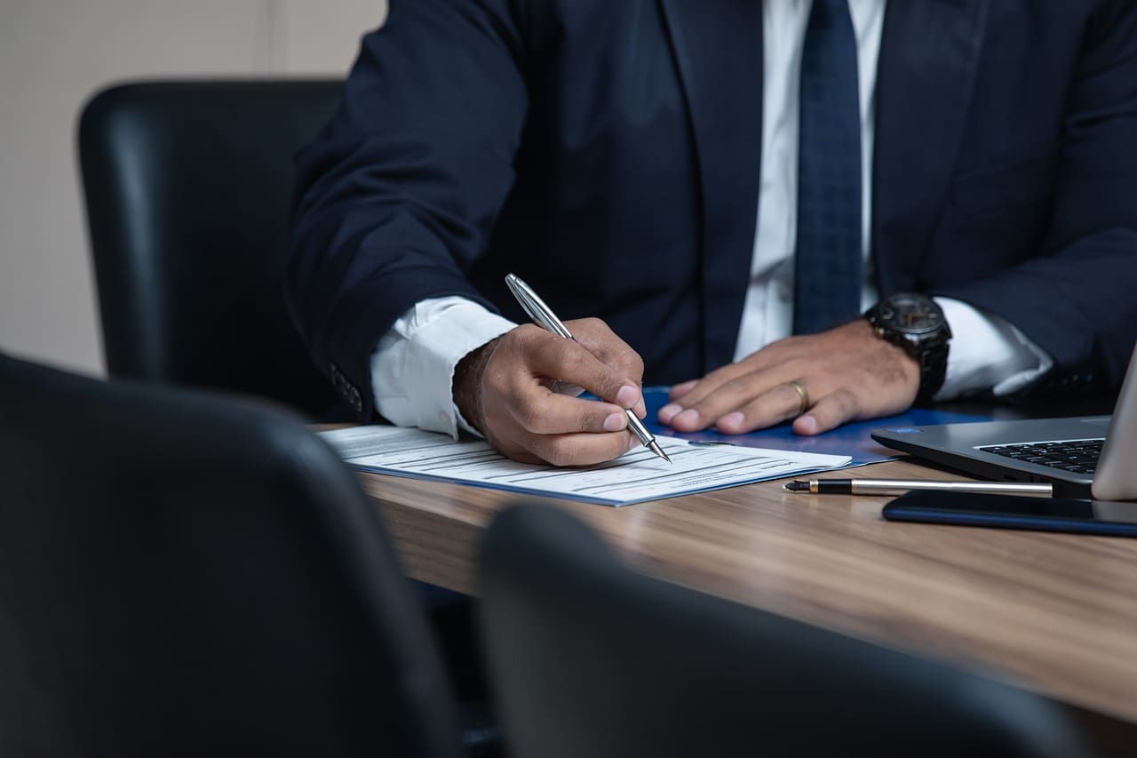 Businessman signing a document at a desk.