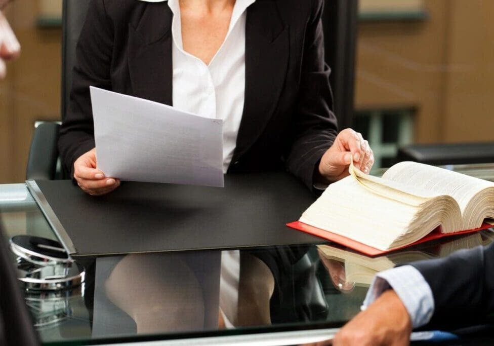 A woman in a suit reviewing legal documents.